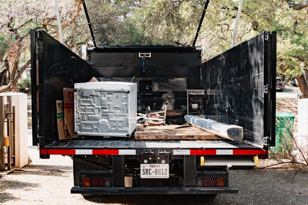 junkstart junk removal truck filled with washing machine and other junk that's about to be hauled away