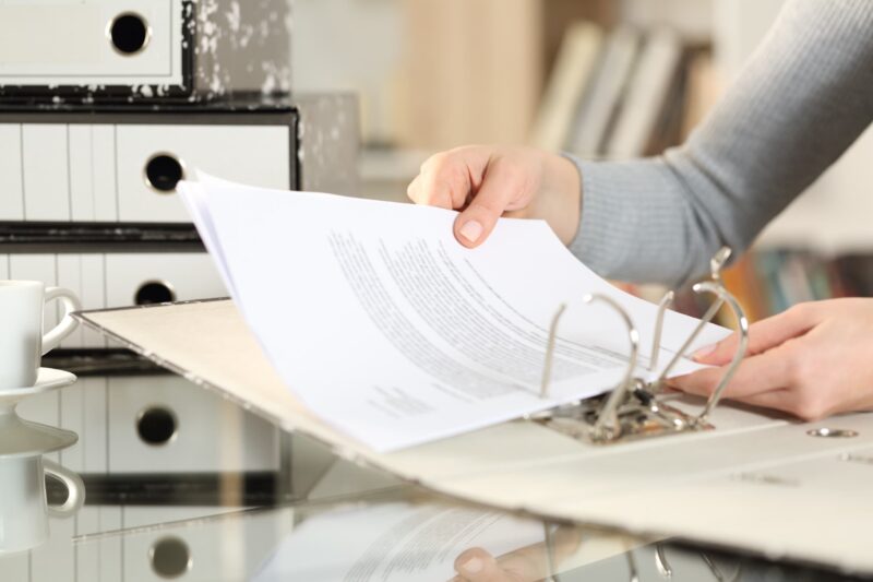 woman organizing her paperwork in binder