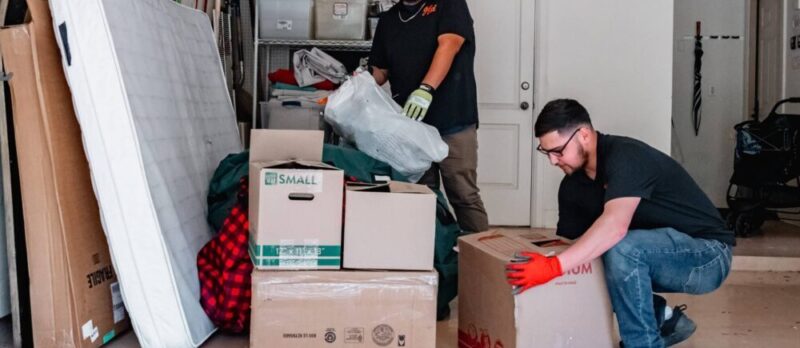 junkstart technicians removing boxes that are piled up in a garage in san antonio
