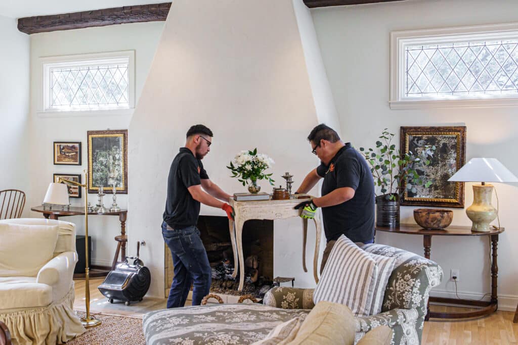 junkstart technicians removing a table while performing a whole-home estate cleanout