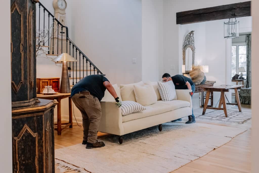 junkstart technicians removing a large cream colored couch from home in san antonio