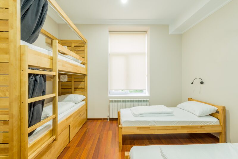 a clean, empty room with two beds, side tables, and lamps