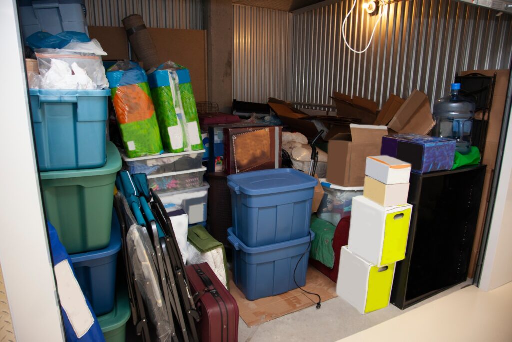 a storage unit full of boxes and other items messily stacked in piles