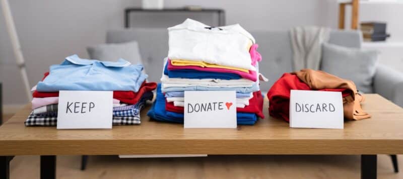 closeup of a few stacks of shirts that are lined up to keep, donate and discard