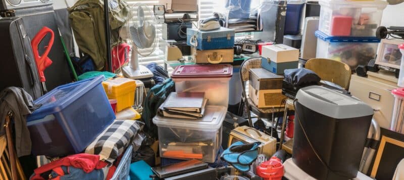 Cluttered storage area filled with various boxes, bins, and household items