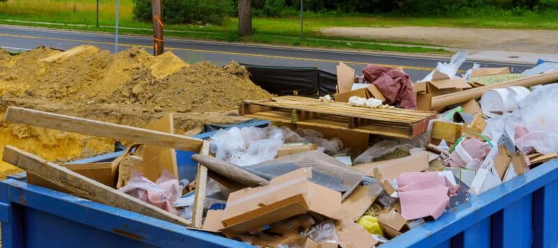 large trash bin filled with trash after construction project